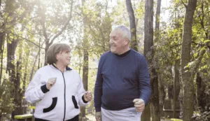two active seniors engaging in conversation while walking in a park