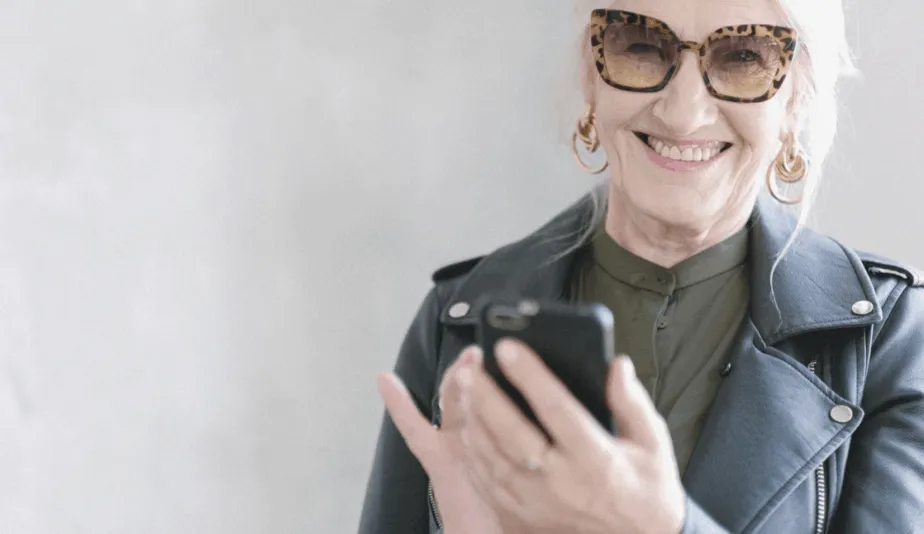 senior woman holding a phone and laughing
