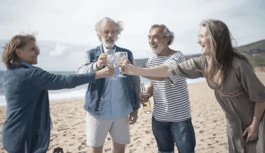 group of seniors toasting on a beach