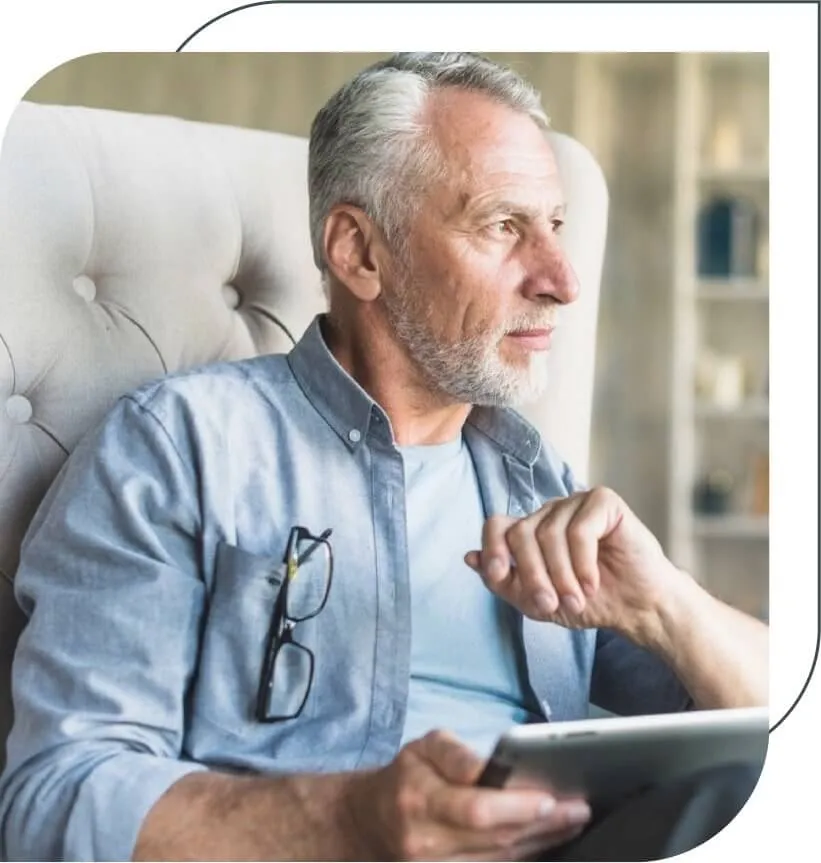 older man holding a tablet and thinking