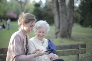 younger woman showing an elderly woman something on a smartphone