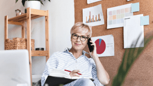 older woman sitting in an office talking on the phone