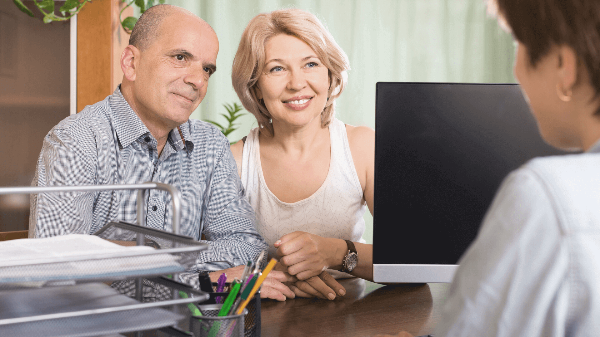 senior man and woman talking to a financial advisor about money in retirement