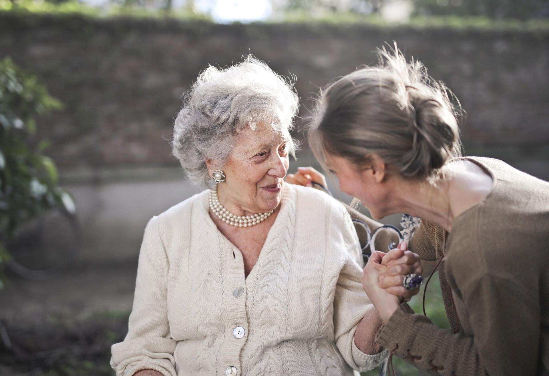 senior woman smiling to a younger woman
