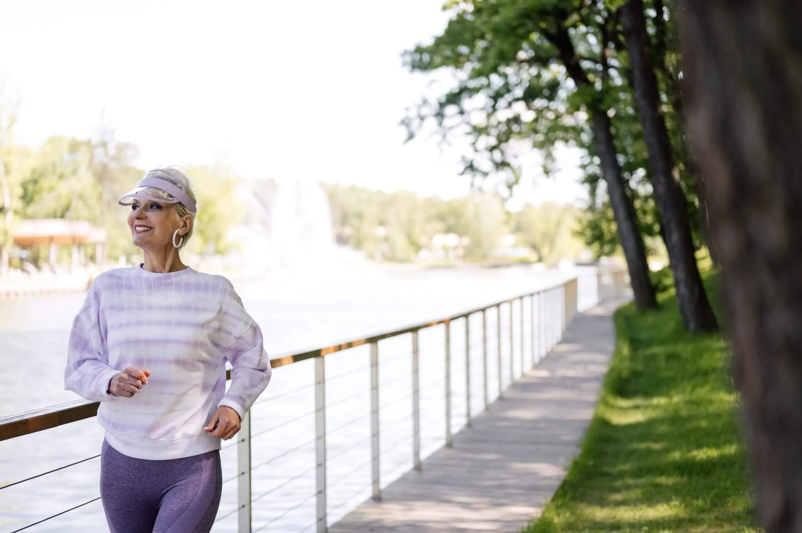 senior woman jogging next to a river