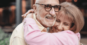 older man and woman hugging and laughing