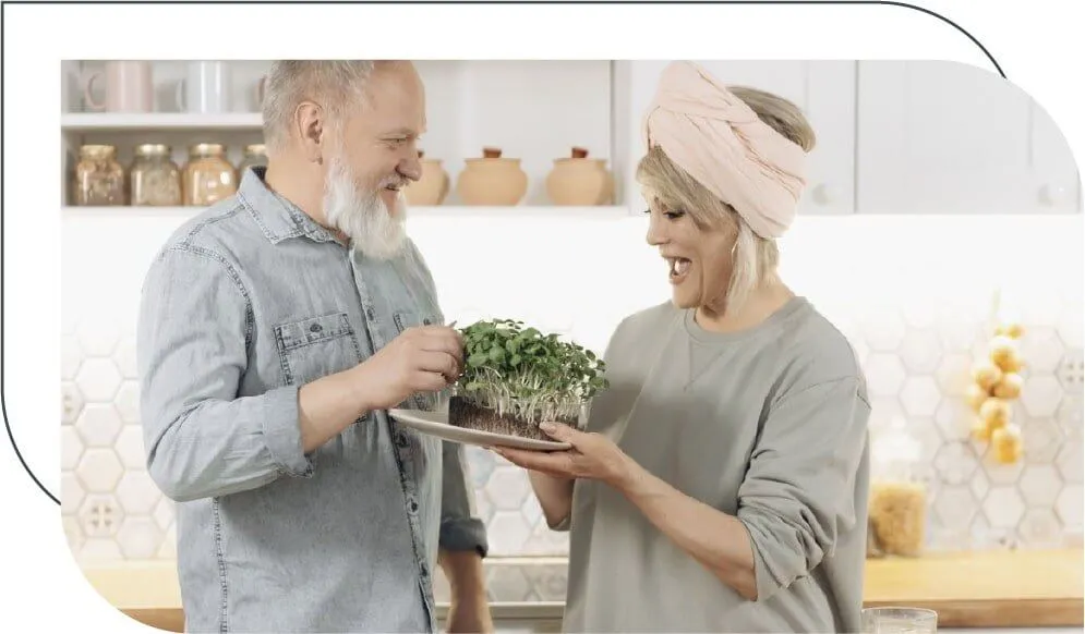 senior couple holding a salad and laughing