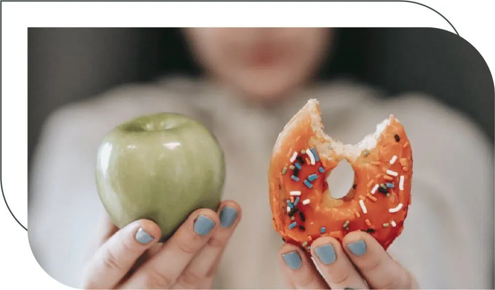 woman holding an apple and a donut