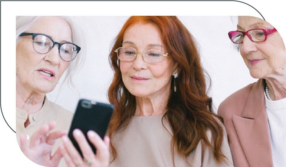 three senior women looking at phone