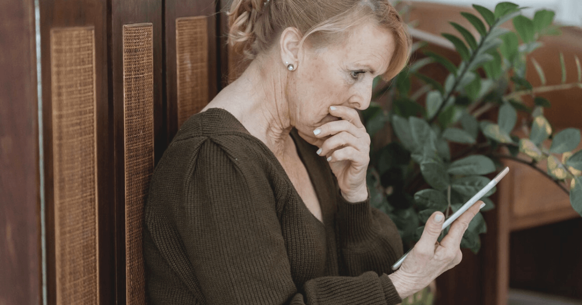worried senior woman looking at a phone