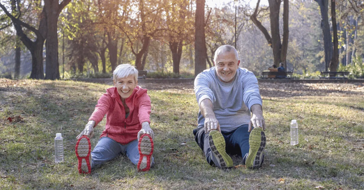 two older adults exercising in the park