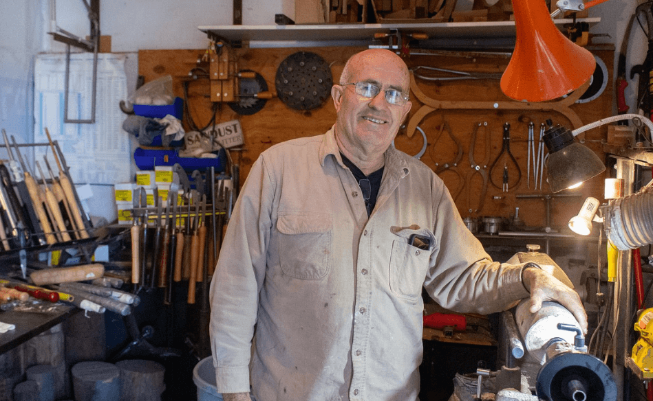 merle hardy, a retired landscaper, in his woodworking garage surrounded by tools
