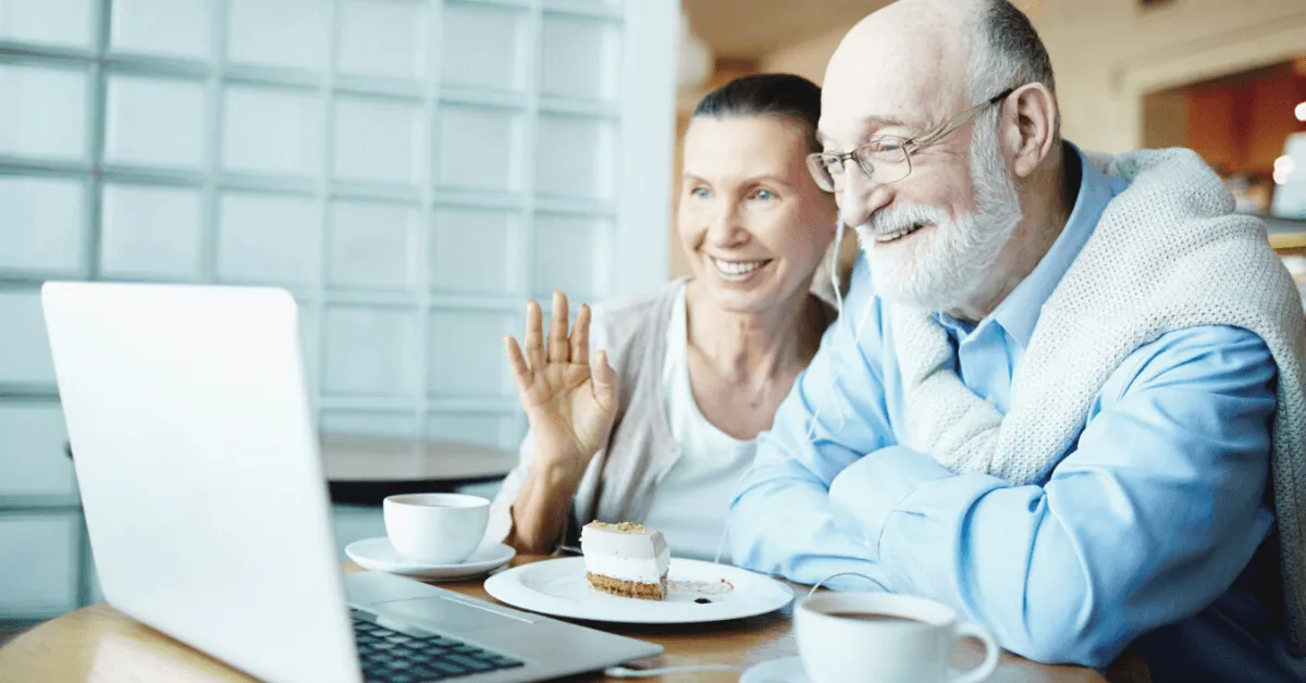 a senior couple chatting with someone virtually through a laptop