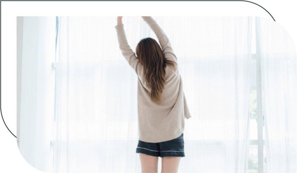 woman stretching in front of a window