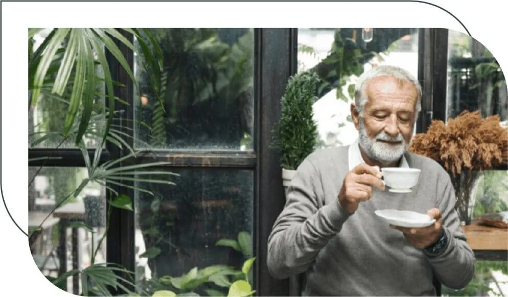 senior man drinking from a cup in garden