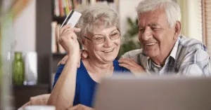 two seniors shopping online with a credit card