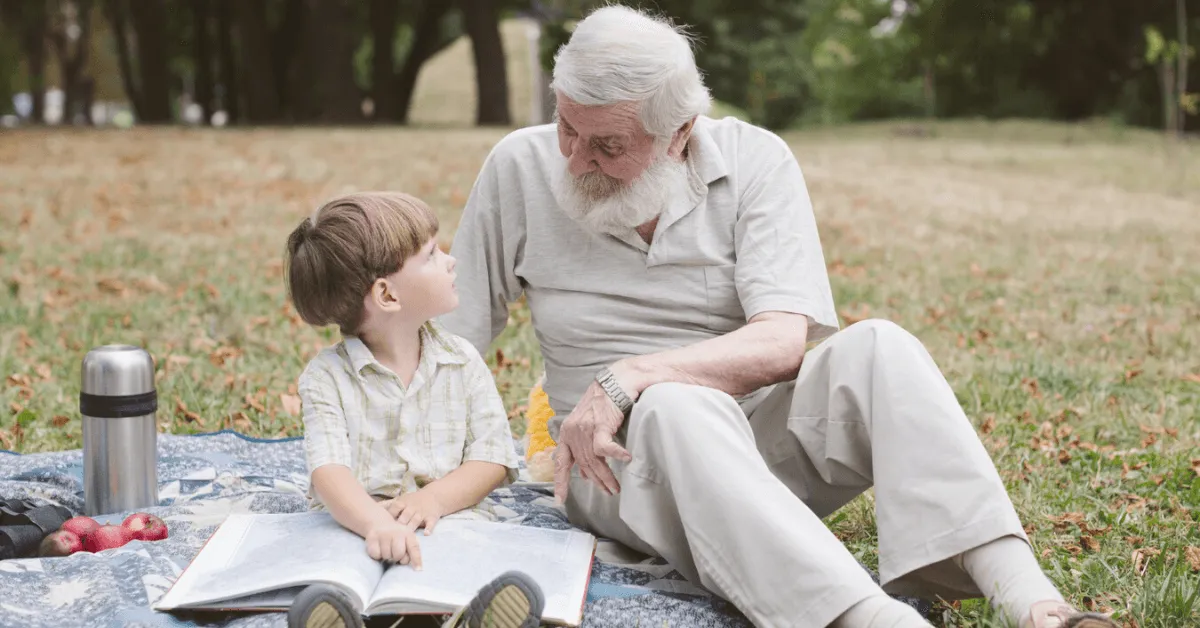 grandpa and grandson reading on a picnic