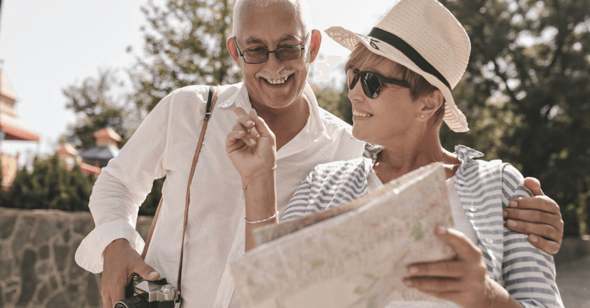 two retired seniors traveling holding a map and a camera