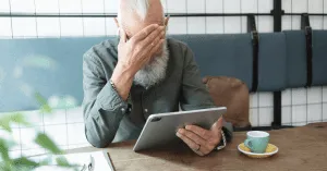 worried senior man holding a tablet