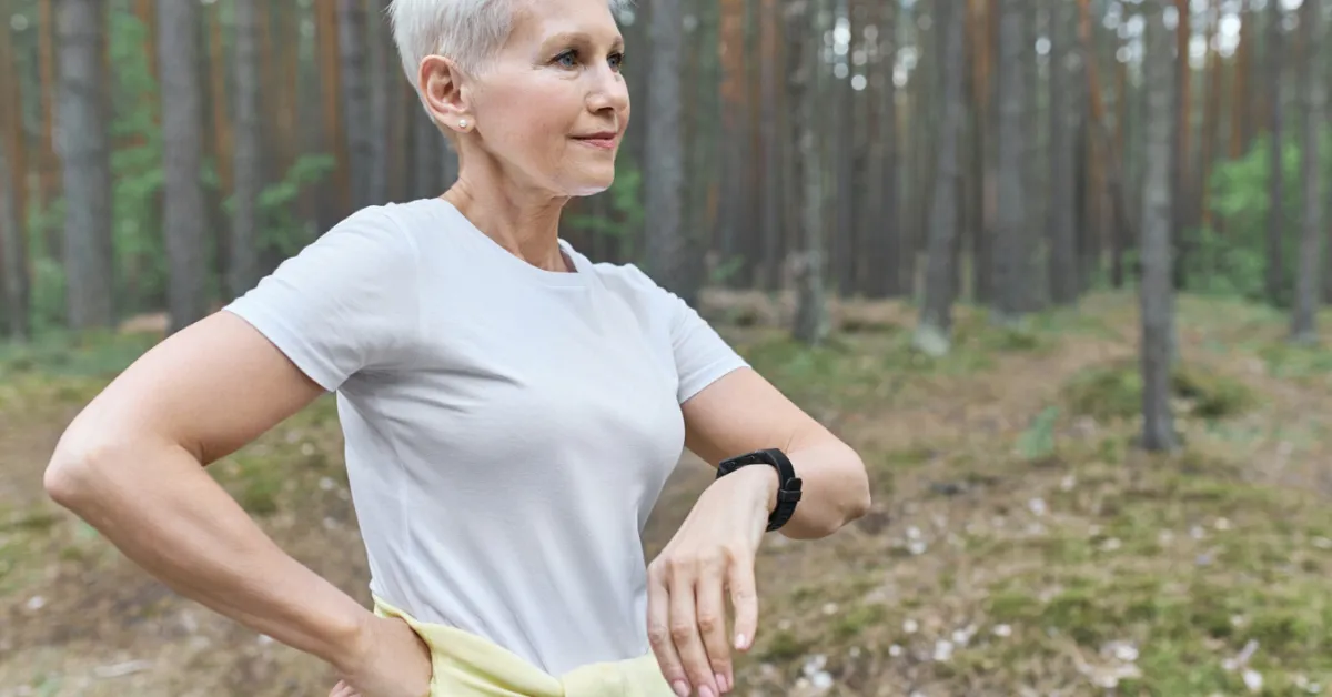 senior woman in the forest with a smartwatch