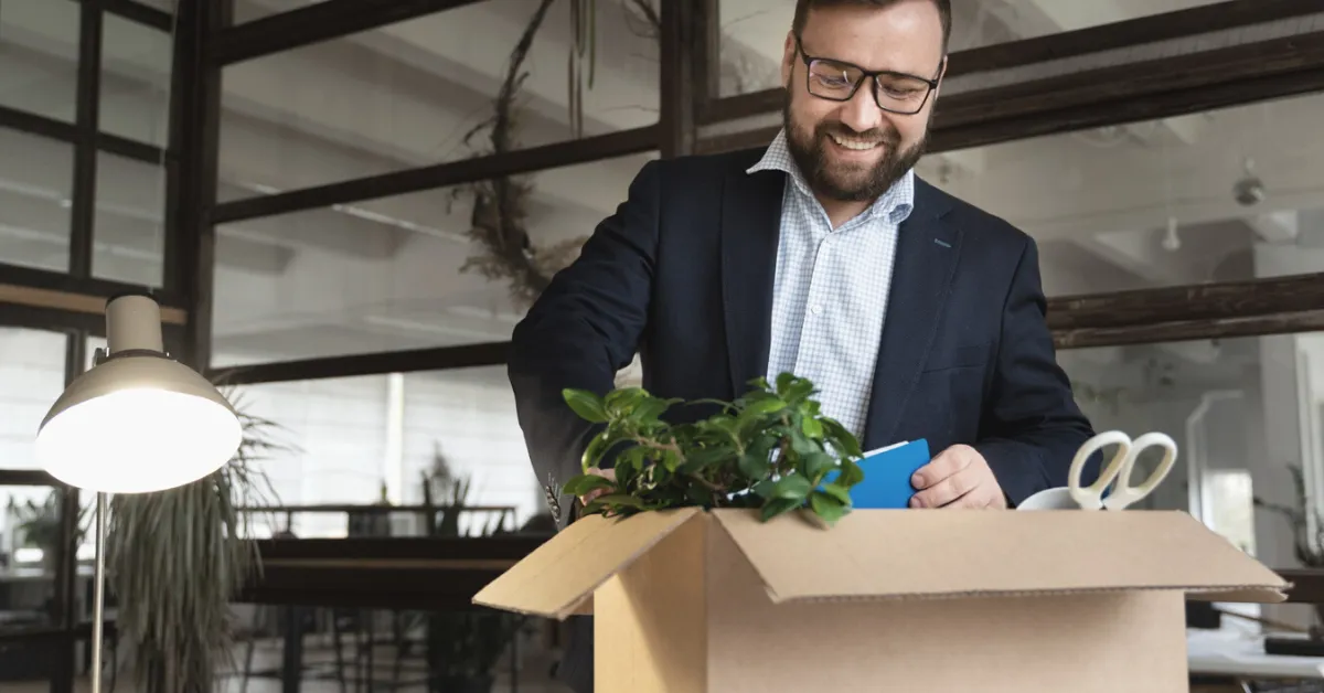 man in an office packing up his belongings